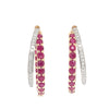 A pair of gold hoop earrings with rows of round-cut pinkish-red rubies and white diamonds, shown against a plain white background.